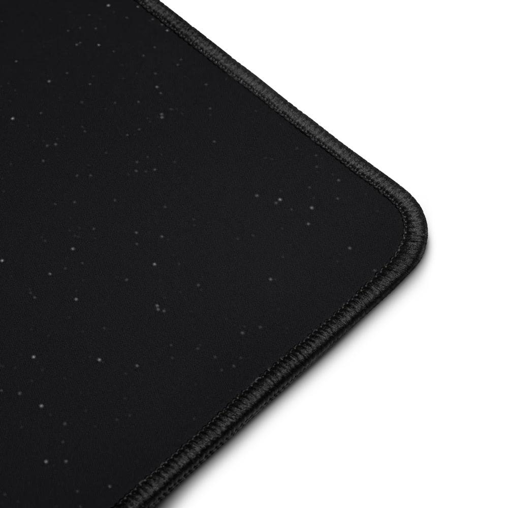 Close-up of one corner of the mat: a starry black surface and a black stitched edge.