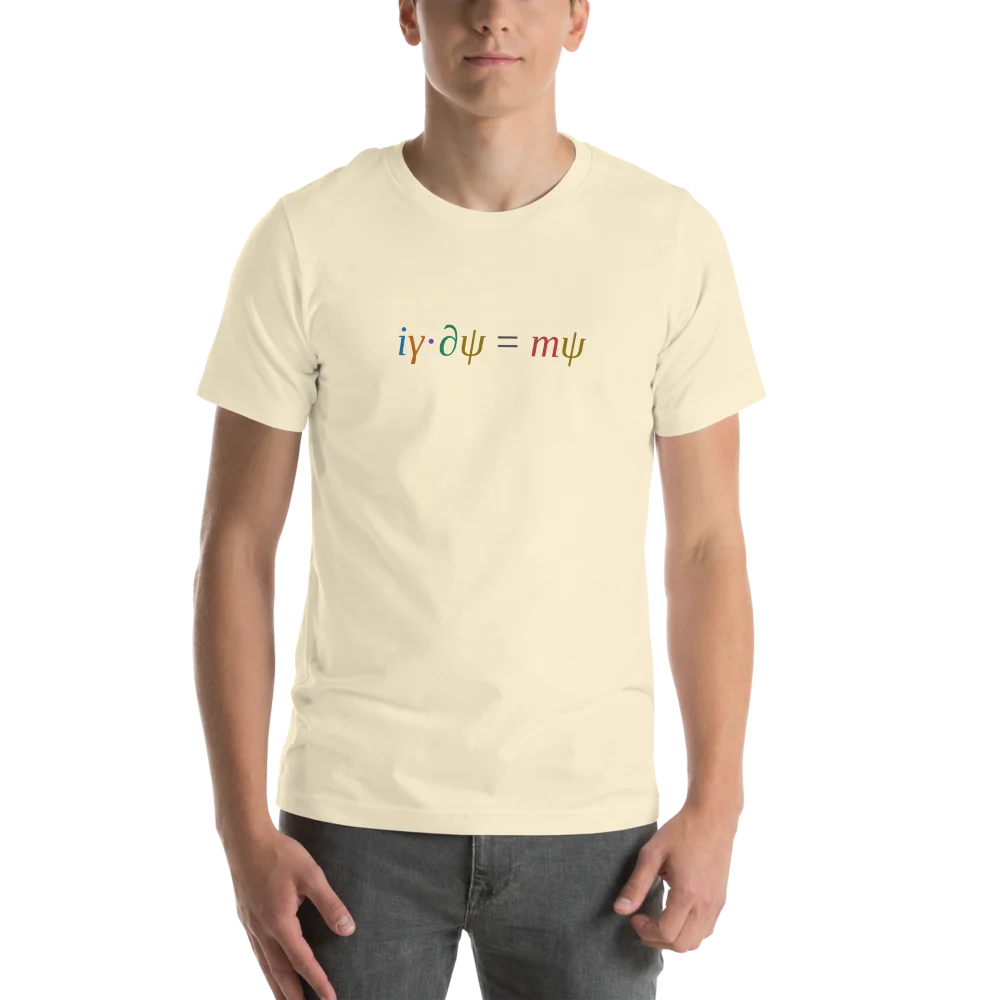 A man wearing a natural, off-white t-shirt with i gamma dot partial psi equals m psi across the chest, each symbol a different deep colour.