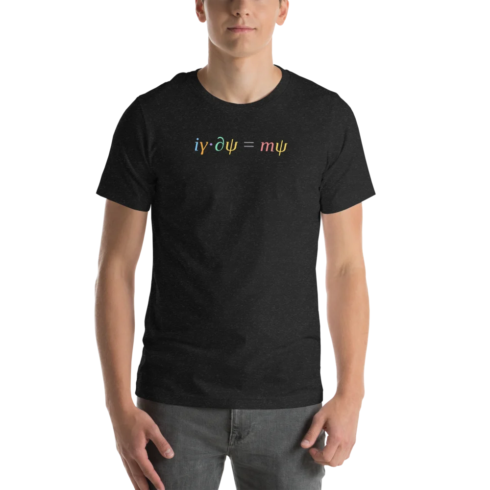 A man wearing a black heather t-shirt with i gamma dot partial psi equals m psi across the chest, each symbol a different colour.